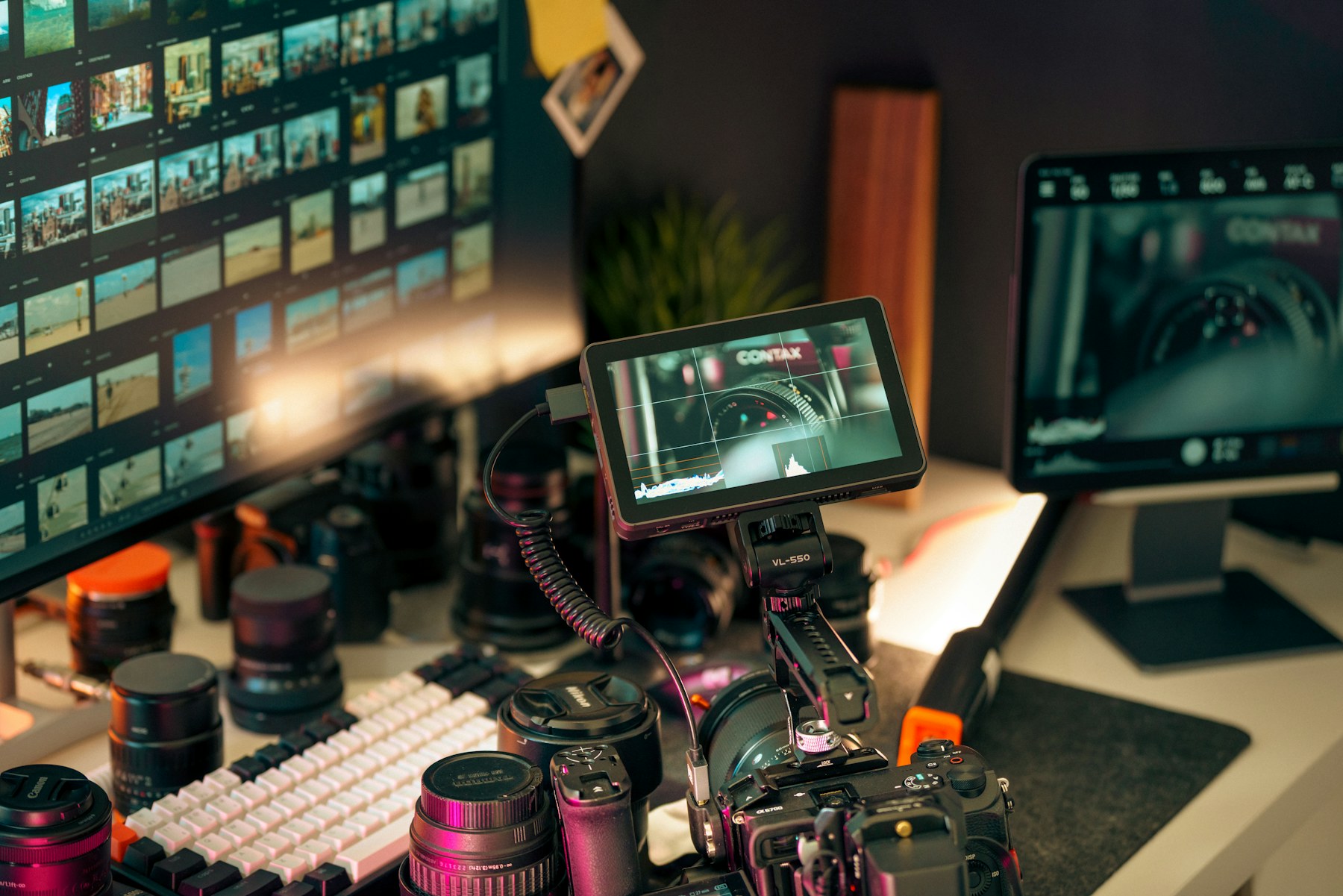 A video editing workspace with camera lenses and multiple production monitors.